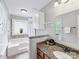 Bright bathroom with tiled tub, glass block window, vanity with granite countertop, and ample cabinet space at 9908 Park Springs Ct, Charlotte, NC 28210