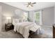 Relaxing bedroom with soft carpet, ceiling fan, neutral colors, and two windows with natural light at 9908 Park Springs Ct, Charlotte, NC 28210
