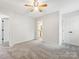 Spacious bedroom with light gray carpet, two doors, and an open bathroom entrance at 9908 Park Springs Ct, Charlotte, NC 28210