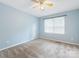 Blue bedroom with soft carpet, ceiling fan, one window with natural light, and neutral colors at 9908 Park Springs Ct, Charlotte, NC 28210