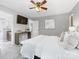 Large bedroom boasts a ceiling fan, stylish console table, and a connecting door to the bathroom at 9908 Park Springs Ct, Charlotte, NC 28210