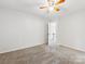 Bedroom with carpet floors, light walls, ceiling fan, and door to the hallway at 9908 Park Springs Ct, Charlotte, NC 28210