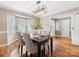 Dining room featuring hardwood floors, a modern light fixture, and a bay window offering abundant natural light at 9908 Park Springs Ct, Charlotte, NC 28210