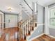 Inviting entryway with hardwood floors, stairs, and a bright white front door with glass paneling at 9908 Park Springs Ct, Charlotte, NC 28210