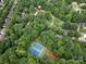 Aerial view of a wooded community with tennis courts and a playground at 113 Foxfield Ln, Matthews, NC 28105