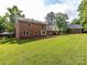 Expansive backyard featuring a lush lawn and a classic brick home at 113 Foxfield Ln, Matthews, NC 28105