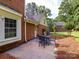 A stone patio with a dining set adjacent to the brick house at 113 Foxfield Ln, Matthews, NC 28105
