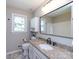 A well lit bathroom with a large vanity and countertop, toilet, and large mirror at 113 Foxfield Ln, Matthews, NC 28105