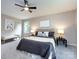 A well-lit main bedroom featuring a plush carpet, a large bed, and a ceiling fan at 113 Foxfield Ln, Matthews, NC 28105