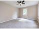 Well-lit bedroom with gray carpet, white trim, ceiling fan and a bright window at 113 Foxfield Ln, Matthews, NC 28105