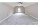 Large carpeted bonus room with vaulted ceiling and natural light at 113 Foxfield Ln, Matthews, NC 28105