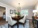 Formal dining room featuring hardwood floors, a stylish light fixture, and a large window at 113 Foxfield Ln, Matthews, NC 28105