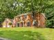 View of a charming two-story brick home with an attached garage, and lush green lawn at 113 Foxfield Ln, Matthews, NC 28105