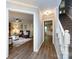 Hallway view leading to rooms, featuring wood floors, white trim, and staircase at 113 Foxfield Ln, Matthews, NC 28105