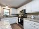 Bright kitchen boasts granite counters, stainless appliances, and white cabinetry at 113 Foxfield Ln, Matthews, NC 28105