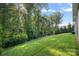 Large, grassy backyard with mature trees and a black fence providing privacy at 114 Canoe Pole Ln, Mooresville, NC 28117