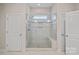 Walk-in shower in a bathroom with glass door, tile surround, and a built-in bench at 114 Canoe Pole Ln, Mooresville, NC 28117