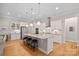 Bright kitchen featuring a large island with barstool seating, pendant lights, and stainless appliances at 114 Canoe Pole Ln, Mooresville, NC 28117