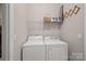 Laundry room featuring a washer, dryer, and wire shelving for storage at 114 Canoe Pole Ln, Mooresville, NC 28117