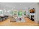 Spacious living room with hardwood floors, a fireplace, and large windows overlooking the backyard at 114 Canoe Pole Ln, Mooresville, NC 28117