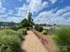 Pathway through landscaped yard leading to lake with community pier and boat dock at 114 Canoe Pole Ln, Mooresville, NC 28117