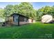 Spacious backyard featuring the home's exterior and a storage shed, surrounded by lush greenery at 121 C And C Ln, Mooresville, NC 28115
