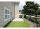 Side yard with well-maintained grass, a concrete patio, and a black metal fence at 12321 Aquitaine St, Charlotte, NC 28277