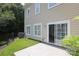 Side view of a home with a backyard patio, lush green grass, and a sliding glass door for indoor/outdoor living at 12321 Aquitaine St, Charlotte, NC 28277