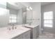 Bathroom featuring double sink vanity, large mirror, and plenty of natural light at 12321 Aquitaine St, Charlotte, NC 28277