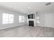 Bright living room with hardwood floors, a fireplace, and large windows offering ample natural light at 12321 Aquitaine St, Charlotte, NC 28277