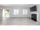 Open-concept living area with sliding glass doors, a fireplace, and modern gray floors at 12321 Aquitaine St, Charlotte, NC 28277