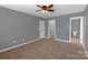 Bedroom features carpeted flooring, a ceiling fan, and access to a closet and bathroom at 1548 Logan Patrick Ct, Gastonia, NC 28052