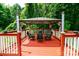 Gazebo on the deck, surrounded by lush greenery, with seating for outdoor relaxation at 1548 Logan Patrick Ct, Gastonia, NC 28052