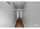 Well-lit hallway featuring hardwood floors and neutral gray walls, leading to multiple rooms at 1548 Logan Patrick Ct, Gastonia, NC 28052