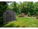Backyard featuring a storage shed and a charming gazebo with seating surrounded by trees at 1548 Logan Patrick Ct, Gastonia, NC 28052