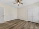 Bright bedroom with wood-look flooring, ceiling fan, and double-door closet at 17136 Red Feather Dr, Charlotte, NC 28277