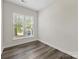 Neutral bedroom featuring window with blinds and wood-look flooring at 17136 Red Feather Dr, Charlotte, NC 28277