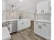 Open kitchen layout features an island, stainless steel dishwasher, and sleek white cabinetry at 17136 Red Feather Dr, Charlotte, NC 28277