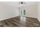 Bright living room features wood-look floors, ceiling fan, and doors to the outdoors at 17136 Red Feather Dr, Charlotte, NC 28277