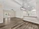 Living area and kitchen combo with balcony access, ceiling fan, and wood-style flooring at 17136 Red Feather Dr, Charlotte, NC 28277