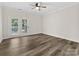 Bright living room features wood-look floors, ceiling fan, and doors to the outdoors at 17136 Red Feather Dr, Charlotte, NC 28277