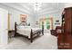 Light-filled bedroom with an iron bed frame, tray ceilings and a reading chair at 172 Hunters Hill Dr, Statesville, NC 28677
