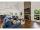 Open-concept living area with stone fireplace, TV, mantel, hardwood floors and comfortable blue furniture at 174 Bellingshire Dr, Mt Ulla, NC 28125