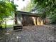 Shows a brick home exterior with basic back patio and trees at 1824 Maribel Ave, Charlotte, NC 28216