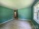 Bright living room with new floors, green walls and a view into the hallway at 1824 Maribel Ave, Charlotte, NC 28216