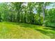 Lush, grassy backyard with mature trees providing ample shade at 2004 Viscount Dr, Matthews, NC 28104