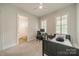 A neutral bedroom has lots of light, with an ensuite bathroom and simple desk at 2004 Viscount Dr, Matthews, NC 28104