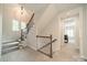 Hallway with staircase featuring carpeted steps, wood railing, and natural light from nearby windows at 2004 Viscount Dr, Matthews, NC 28104