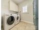Well-equipped laundry room featuring a modern washer and dryer and ample storage cabinets at 2004 Viscount Dr, Matthews, NC 28104
