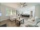 Bright open-concept living room featuring hardwood flooring, white furniture, and a view into kitchen at 2004 Viscount Dr, Matthews, NC 28104